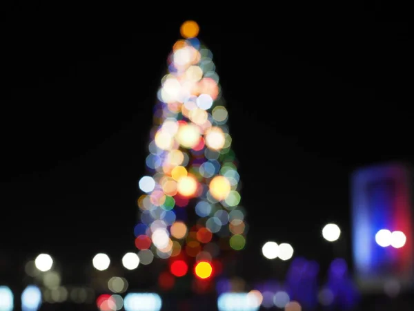 Рождественская елка на городской площади. Абстрактный темный расплывчатый городской фон . — стоковое фото