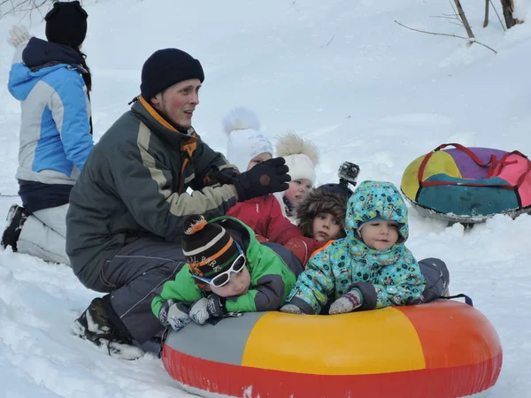 Kinder und Eltern fahren im Winter Snowtubes im Wald. Russland, Saratow - Januar 2016 — Stockfoto