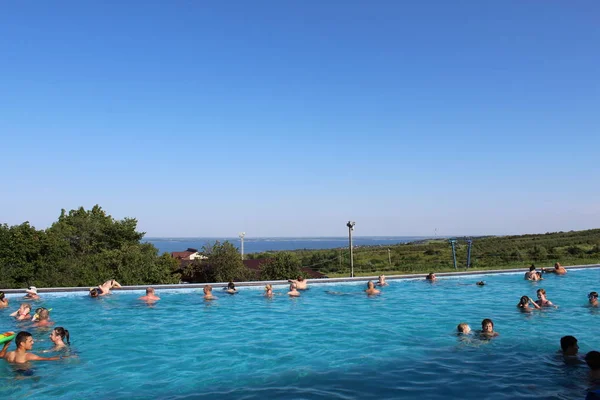 La gente nada en las piscinas al aire libre contra el telón de fondo del pintoresco paisaje de la estación de esquí en el verano. Rusia, Khvalynsk - Julio 2017 —  Fotos de Stock