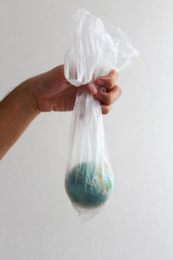 Küre şeklinde bir top plastik bir torbanın içinde. Dünya 'nın plastik kirliliği kavramı