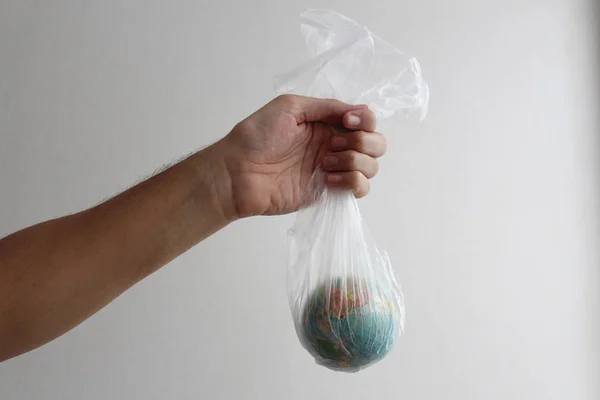 Kugel in Form einer Kugel befindet sich in einer Plastiktüte. Konzept der Plastikverschmutzung der Erde — Stockfoto