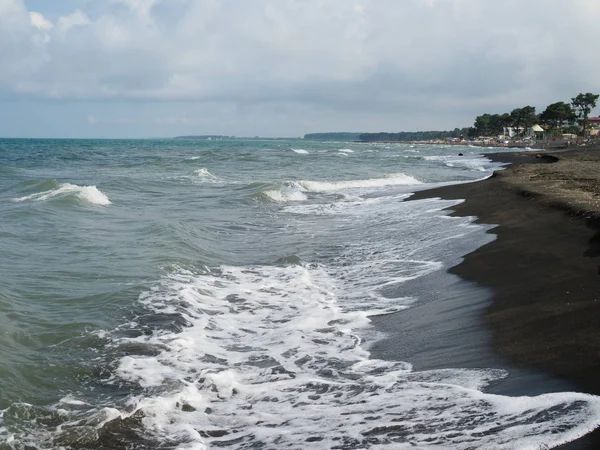 Hermosas olas en el mar y arena negra — Foto de Stock