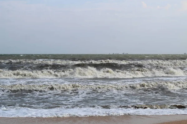 Waves during a storm at sea. in the distance you can see large ships and barges — Stock Photo, Image