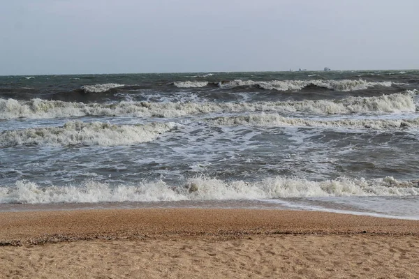 Wellen während eines Sturms auf See. In der Ferne sieht man große Schiffe und Lastkähne — Stockfoto