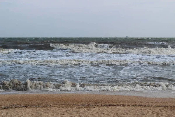 Waves during a storm at sea. in the distance you can see large ships and barges — Stock Photo, Image