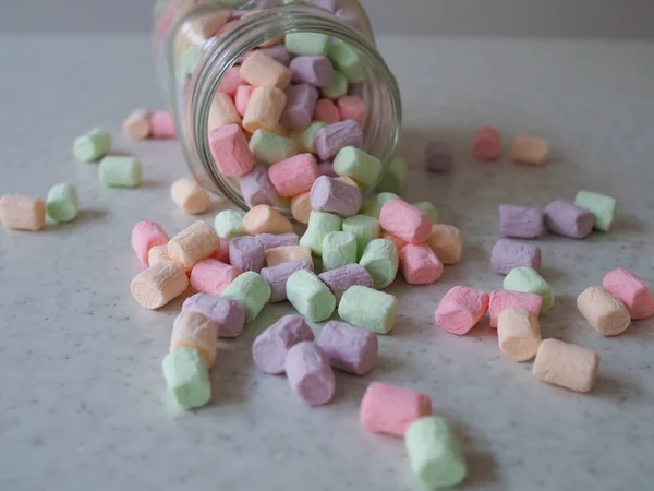 Rózsaszín és fehér marshmallows ömlött a tároló edény, mint régi fa háttér. Vintage hatást szándékos matrica — Stock Fotó