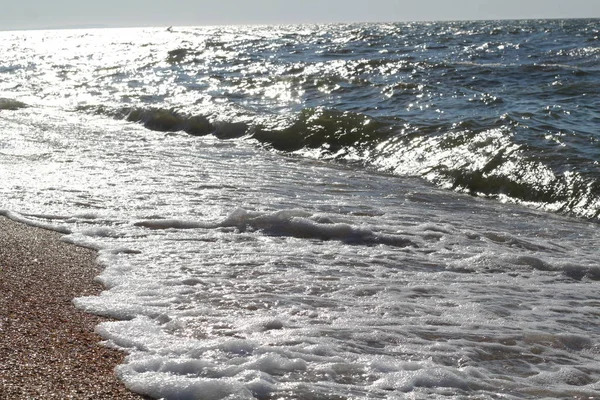 Dalgalar deniz sahil plaj güzel sıçramalarına parlak güneşli bir günde — Stok fotoğraf