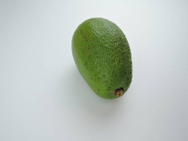 Beyaz arkaplanda yeşil bir avokado izole edilmiş.