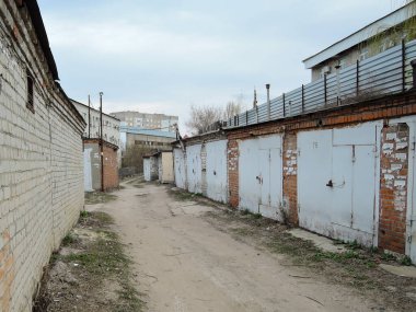 Rusya'da kapalı metalik kapılar ile eski beton garajlar tipik kompleksi. perspektif ile garajlar aracılığıyla driveway yol