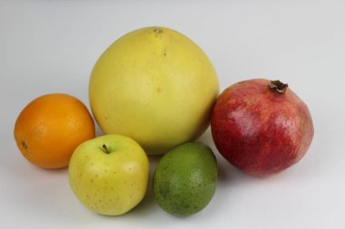 ripe fruit on a white background: pomegranate, pomelo, orange, avocado,
