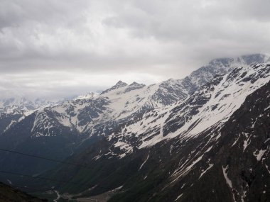 bulutlu havada karla kaplı dağın tepeleri