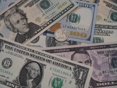 1 dolarlık banknotun arka planına karşı 1 ruble para, yakın plan. Altında Rusça harflerle yazılmış ruble var.,