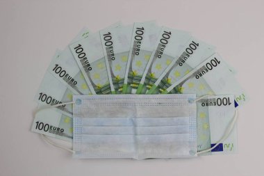 Avrupa 'da koronavirüsün yayılması konsepti. Beyaz arka planda 100 Euro 'nun üzerinde tıbbi maske.