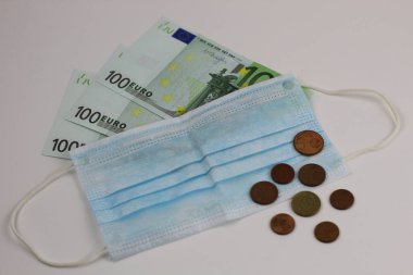 Avrupa 'da koronavirüsün yayılması konsepti. Beyaz arka planda 100 Euro 'nun üzerinde tıbbi maske