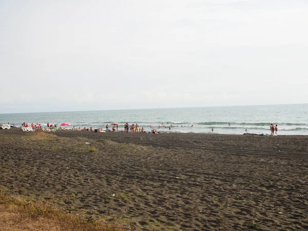 Las Personas Desconocidas Relajan Playa Arena Magnética Negra Del Mar — Foto de Stock