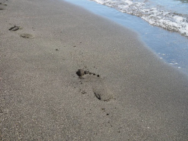 Fußabdrücke Einem Schwarzen Sandstrand Mit Tilt Shift Unschärfe Surfen Hintergrund — Stockfoto