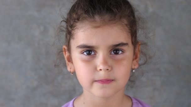 Porträt eines kleinen Mädchens mit einem zahnlosen Lächeln. ein schönes Mädchen mit einem schiefen Zahn, der herausfällt. um die Abwesenheit von Zähnen zu zeigen. — Stockvideo