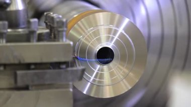 Torna fabrikada metal parçası üretiyor. Torna tezgahının işlenmesi. Metal torna tezgahında. Ağır endüstriyel mekanik ekipmanlar. Kapatın. 4K Yavaş Hareket