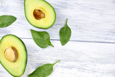 Beyaz arka plan üzerinde avokado dilimleri. Tam ve yarım yaprakları ile.