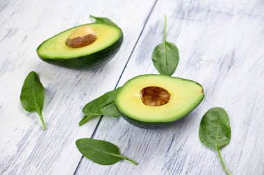 Beyaz arka plan üzerinde avokado dilimleri. Tam ve yarım yaprakları ile.