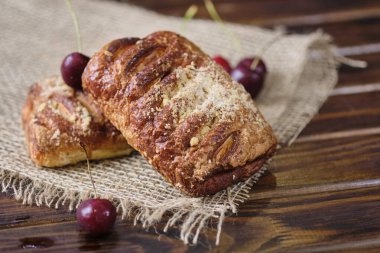 Ahşap bir arka plan üzerinde çuval üzerinde kiraz reçeli ile Puffs. Rustik stil