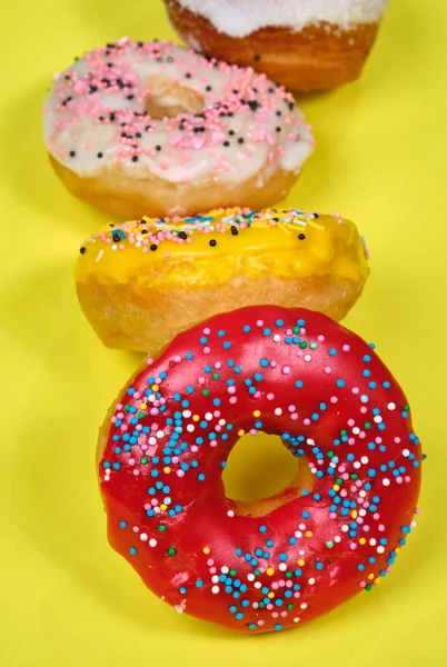 Donuts multicoloridos em um fundo amarelo, espaço para texto Imagens De Bancos De Imagens Sem Royalties