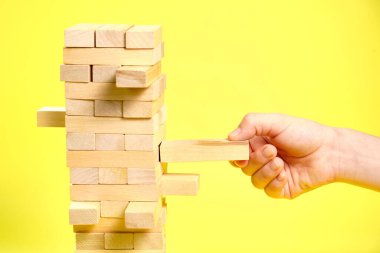Sarı zemin üzerinde tahta oyun jenga blokları,