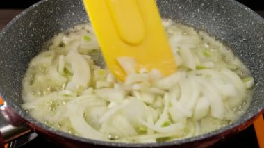 Kızartma tavasında soğan kızartılıyor, tereyağında, yakın plan.