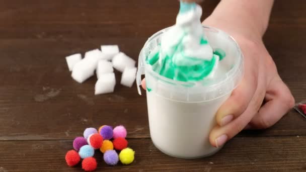 We make slime at home. making popular childrens toys from glue.. Childrens hands make a toy out of slime on a blue background. — Stock Video