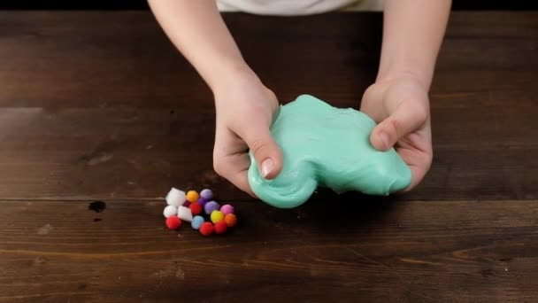 푸른 배경의 어린이들의 손에 그린 은 끈적끈적 한 장난감을 쥐고 있었다. 점액을 만들기 위해서요. 복사 공간. 플 래들리. — 비디오