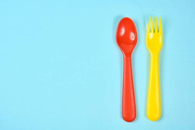 Mavi arka planda çok renkli plastik tabaklar. Plastik ve ekolojinin çevre kirliliği kavramı. metin için yer,