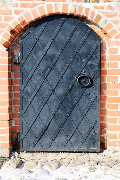 bir tuğla duvar eski demir kapıdan.