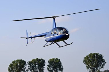Mavi gökyüzünde uçan helikopter.