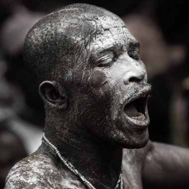 Ouidah, Benin 10 Ocak 2012: Voodoo festivali - İnsanoğlu varillerin ritmine kapılmıştır ve yüzünde yağ ve beyaz toz vardır.