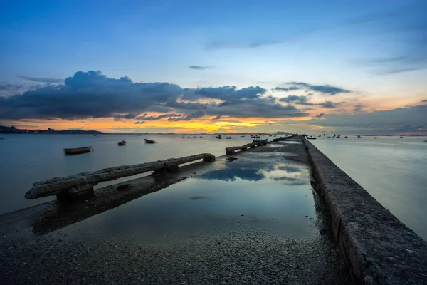 Pôr do sol sobre o mar e reflexão sobre a ponte do cais — Fotografia de Stock