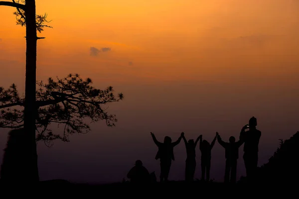 Silhouette Gruppe von Menschen stehen und zeigen ihre Hand in der Sonne — Stockfoto