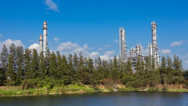 Tidsförskjutning med moln rörelse över petrokemisk, petroleum, kemisk anläggning industri med raffinaderi för att producera petrokemisk produkt med träd och vatten i sjön — Stockvideo