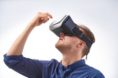 İlk kez elinde beyaz arka plan üzerinde atış Vr gözlük studio aracılığıyla arıyor genç adam kullanarak sanal gerçeklik gözlük hayran