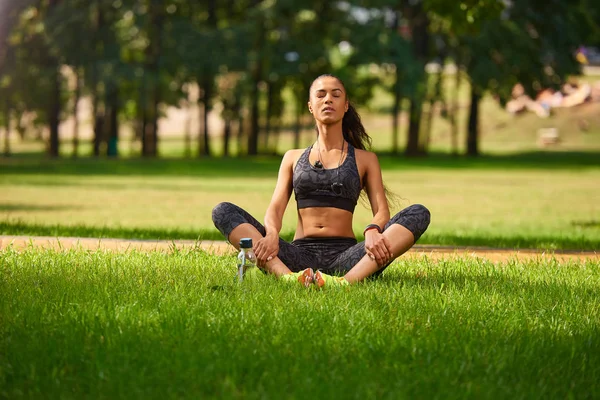 Woman Yoga with closed eyes - relax in nature concept in park
