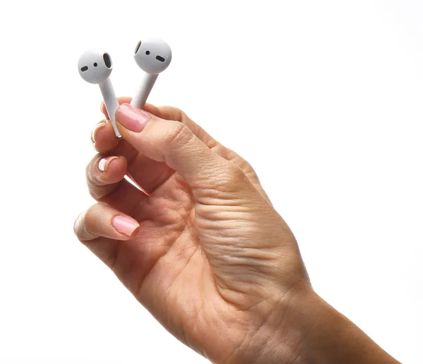 Female Hand Nude Manicure Holding White Wireless Ear Buds Earphones — Stock Photo, Image