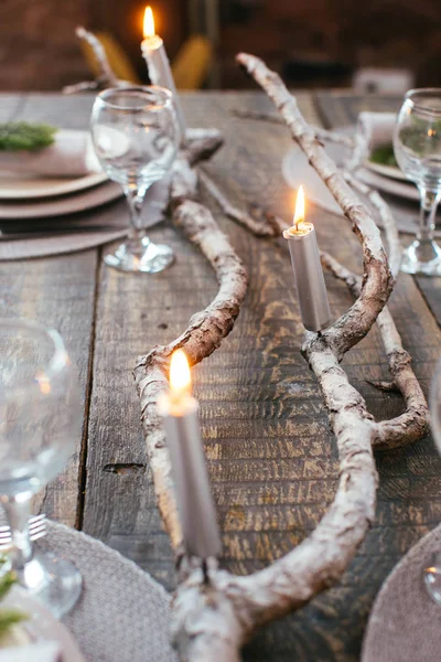 Noel yemeği için mumlar ve dalları ile servis tablo