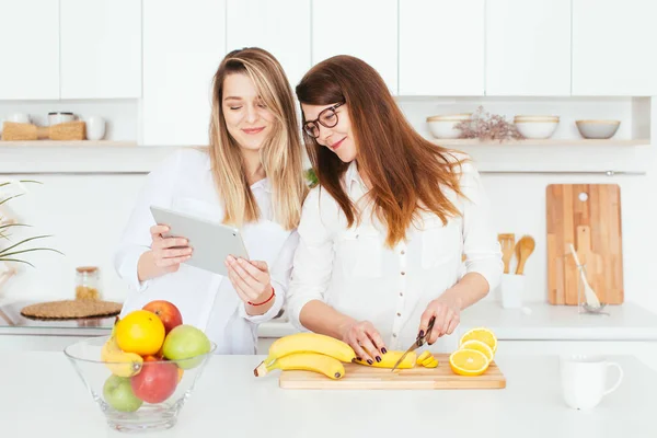 Mujeres jóvenes caucásicas cocinando en la cocina — Foto de Stock