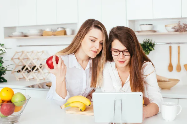 Mujeres jóvenes caucásicas cocinando en la cocina — Foto de Stock