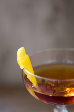 Limonlu ve sallanan bir coupe bardağında alkollü viski kokteyli.