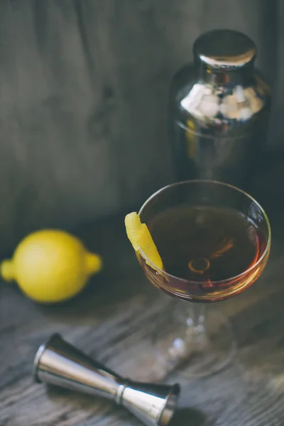 Alkohol whisky cocktail i ett coupe glas med citron och shaker — Stockfoto