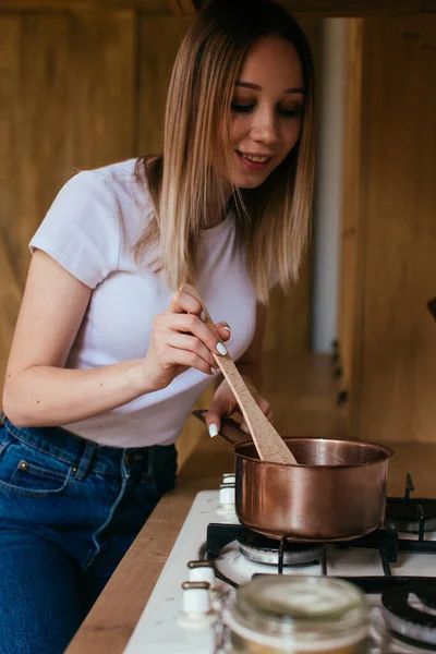 Egy szőke nő portréja, aki táblagéppel főz a konyhájában. — Stock Fotó