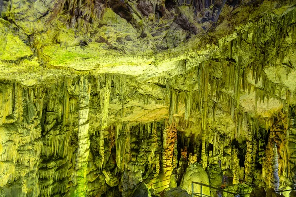 Höhlenfelsformationen sind Stalaktiten und Stalagmiten in buntem Licht. Das Wunder der Stalagmitenbildung in der dunklen Halle, der Zeushöhle, dem Beton. Urlaubs- und Reisekonzept. Horisontal — Stockfoto