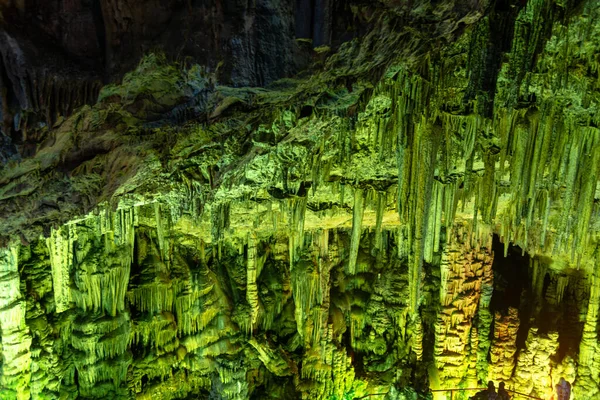 Cave rock formations are stalactites and stalagmites in colorful light. The miracle of the formation of stalagmites in the dark hall, Zeus Cave, Crete. Vacation and travel concept. horisontal