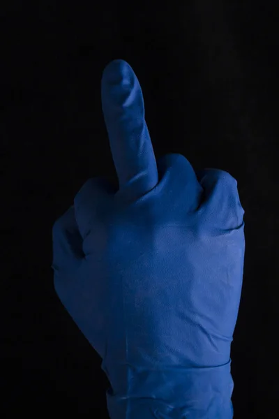 Middle finger foam hand. hand in blue medical glove . Gesture me