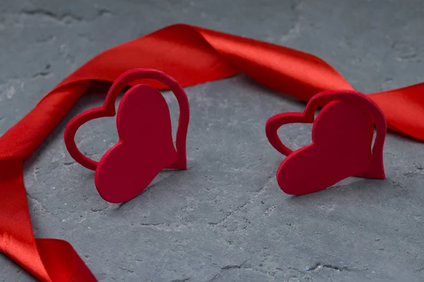 San Valentino. Nastro rosso e cuori rossi. Schienale in cemento grigio — Foto Stock